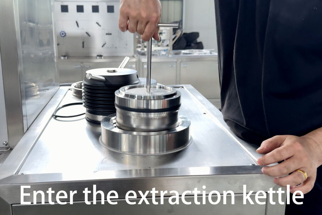 Placing feed container into CO₂ extraction vessel